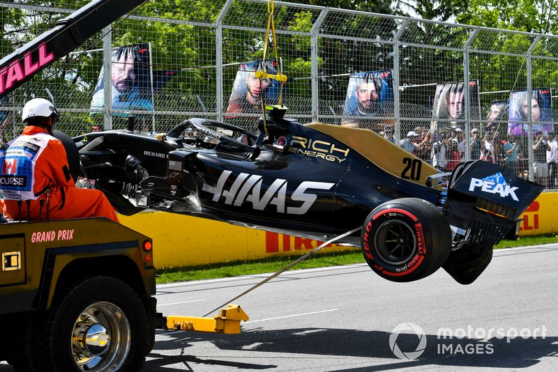 Oficiales retiran el coche dañado de Kevin Magnussen, Haas F1 Team VF-19, del circuito