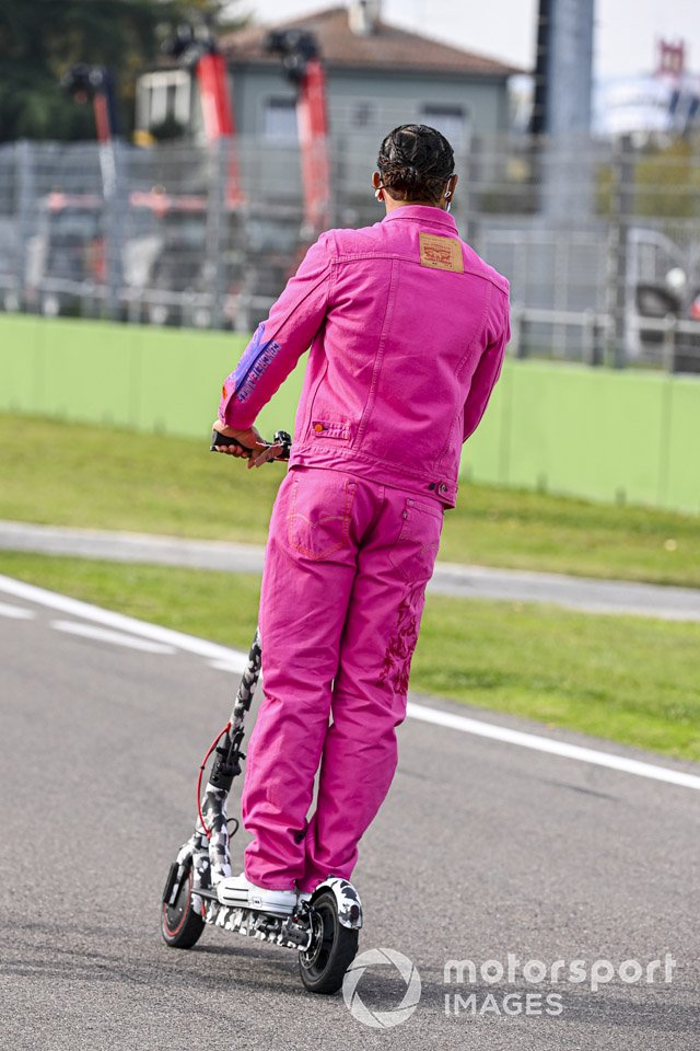 Lewis Hamilton, Mercedes-AMG F1, rides the track on an electric scooter