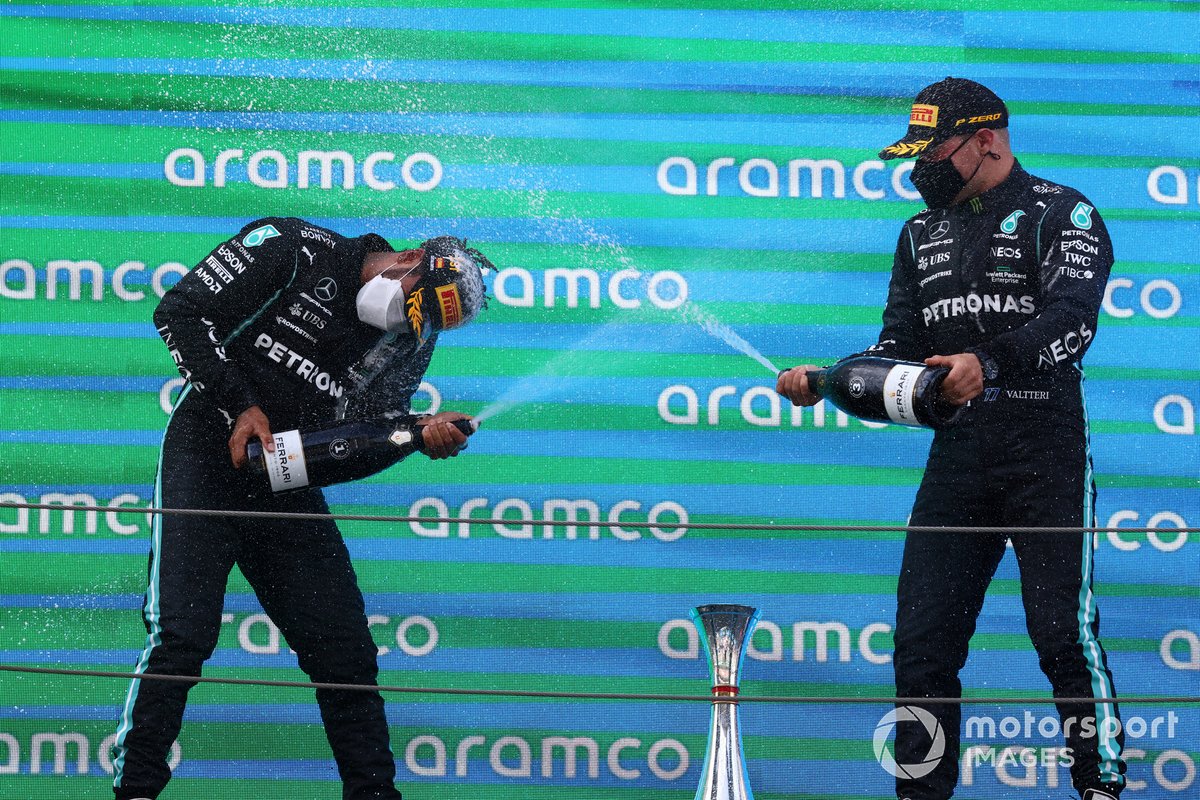 Lewis Hamilton, Mercedes, primera posición, y Valtteri Bottas, Mercedes, tercera posición, se bañan en champán en el podio