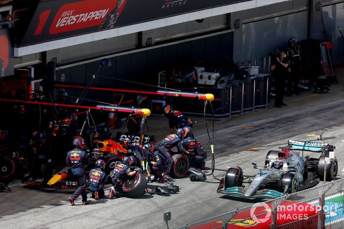 George Russell, Mercedes W13, pasa mientras Max Verstappen, Red Bull Racing RB18, hace una parada en boxes 