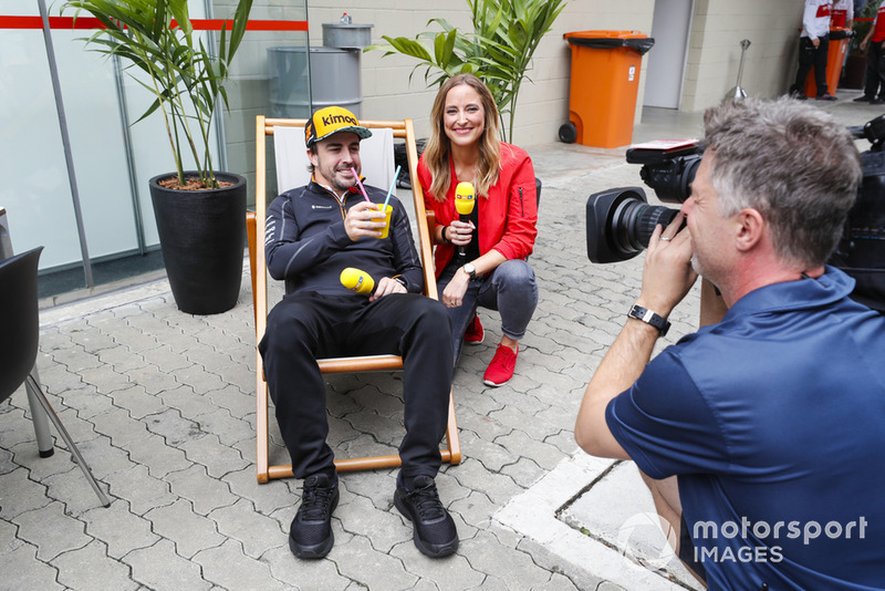 Fernando Alonso, McLaren, siede su una sedia a sdraio con un drink, accanto a una presentatrice RTL