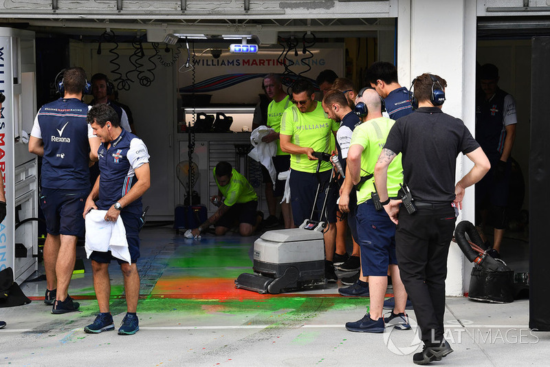 Williams mechanics clean aero paint from the garage floor