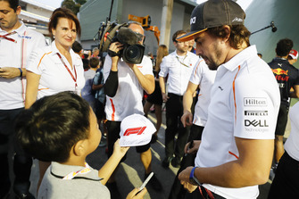 Fernando Alonso, McLaren, signs an autograph for a young fan