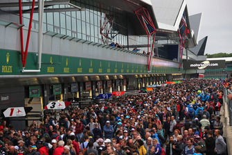 Les fans dans la voie des stands avec les logos Motorsport.com