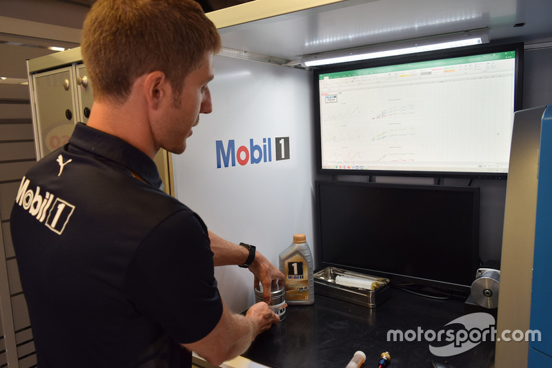 Ingegnere Exxon-Mobil al lavoro nel laboratorio mobile all'interno del box Red Bull
