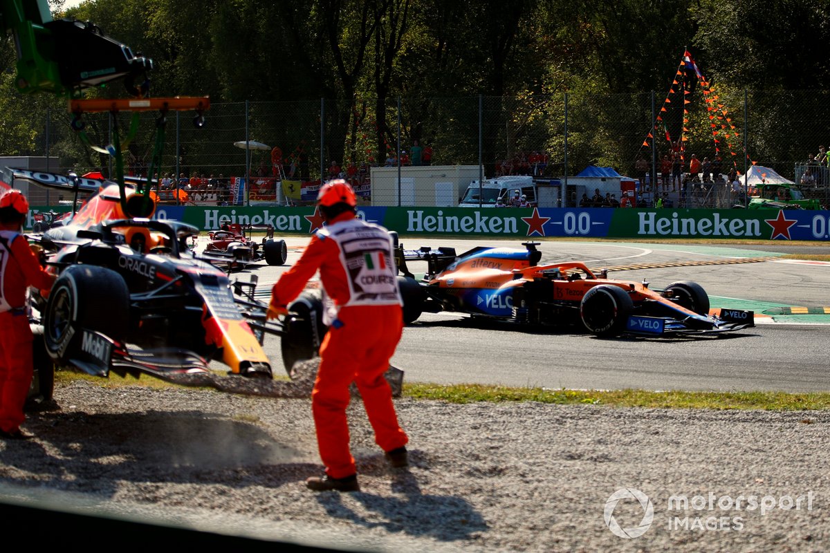 Daniel Ricciardo, McLaren MCL35M, pasa mientras retiran el coche de Max Verstappen, Red Bull Racing RB16B, de la grava