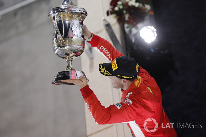 Sebastian Vettel, Ferrari, 1st position, holds up his trophy on the podium