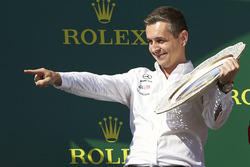 The Mercedes Constructors trophy delegate celebrates with the trophy on the podium