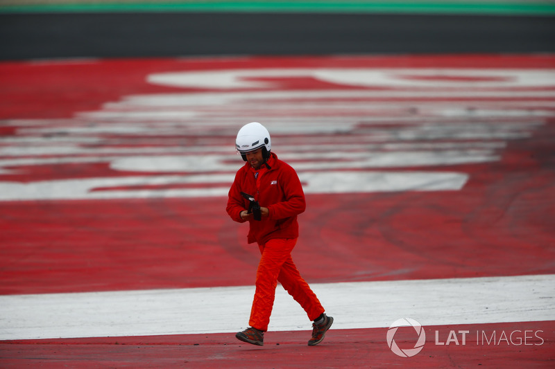 A marshal removes debris from track