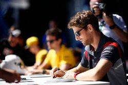 Romain Grosjean, Haas F1 Team, signs autographs alongside Jolyon Palmer, Renault Sport F1 Team