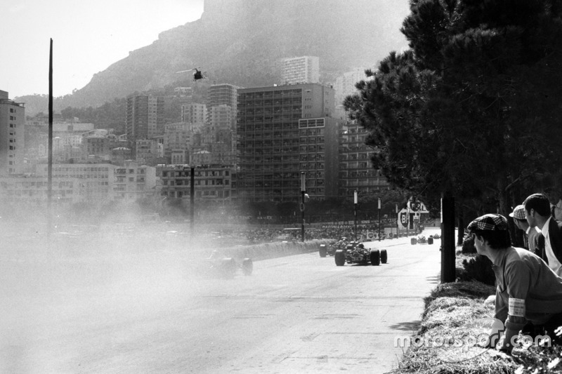 Les voitures passent au travers de la fumée après l'accident de la Ferrari 312 de Lorenzo Bandini.