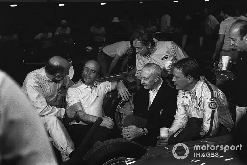 Stirling Moss in conversation with Juan Manuel Fangio with on-lookers Rene Dreyfus, Phil Hill, Dan Gurney and Maurice Trintignant