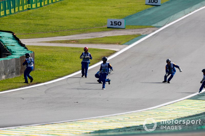 Los oficiales de pista recogen los escombros