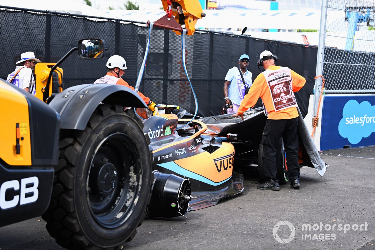 Los oficiales de pista retiran el coche dañado de Lando Norris, McLaren MCL36