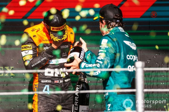 Lando Norris, McLaren, 2ª posición, Fernando Alonso, Aston Martin F1 Team, 3ª posición, celebran en el podio con Champán