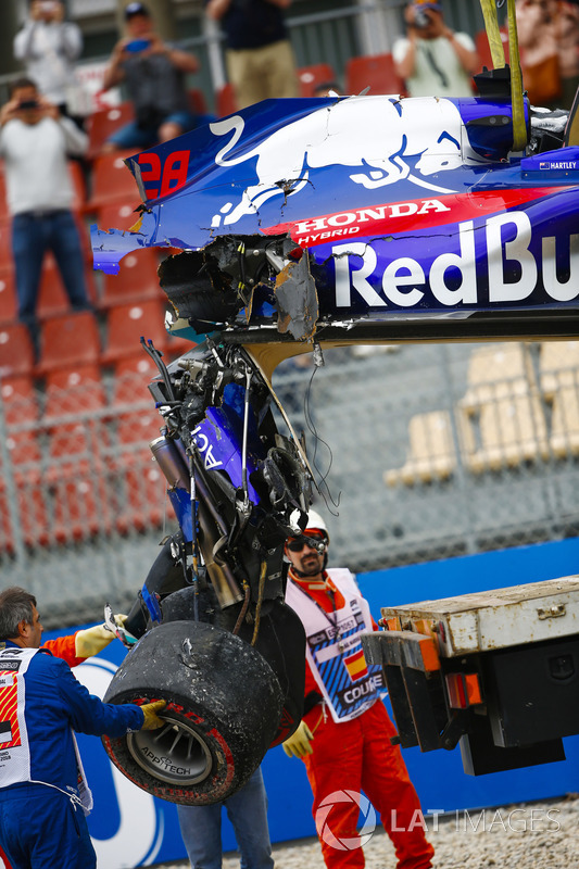 Marshals remove the damaged car of Brendon Hartley, Toro Rosso STR13, from the circuit as the gearbox hangs off the back