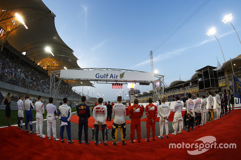 The drivers line up for the national anthem