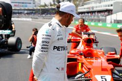 Le troisième Lewis Hamilton, Mercedes AMG F1, inspecte la voiture du poleman Sebastian Vettel Ferrari SF70H