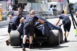 The crashed car of Daniel Ricciardo, Red Bull Racing RB14 is returned to the pits in FP1