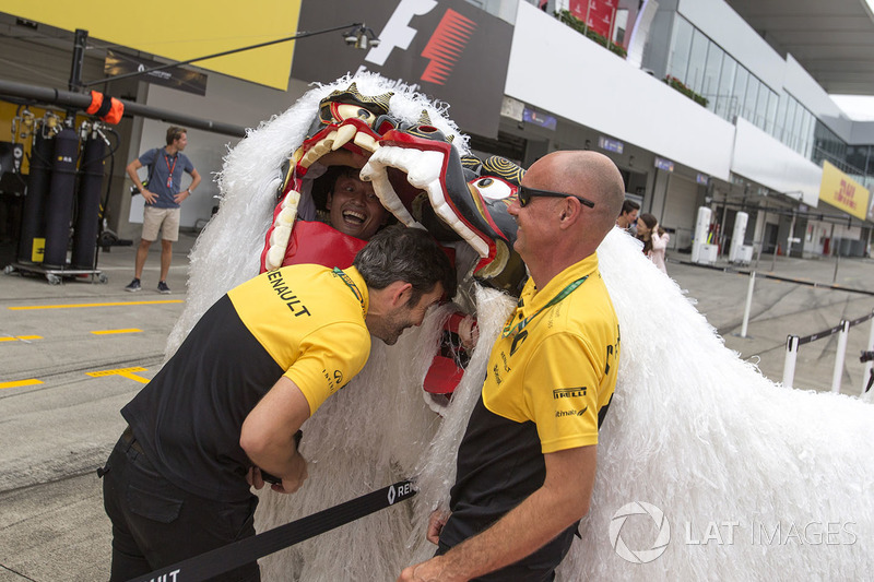 Renault Sport F1 Team mekanikerleri ve ejderha kostümlü insanlar