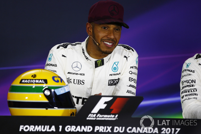 Lewis Hamilton, Mercedes AMG F1, shows off his Ayrton Senna helmet, a gift after equalling the Brazilian's pole record, in the post-qualifying press conference