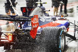 Water sprays from the rears of Carlos Sainz Jr., Scuderia Toro Rosso STR12, in the pit lane