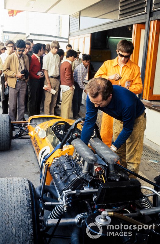 Mechanics work on Bruce McLaren's McLaren M14A Ford in the pits