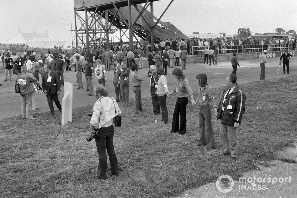 Los oficiales bloquean la pista al limpiarla después de una gran colisión en la primera vuelta