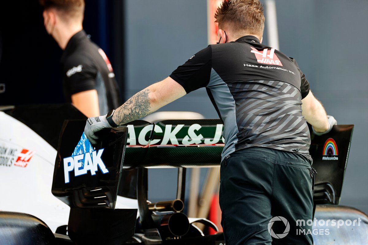 Un mecánico de Haas sostiene el alerón trasero del monoplaza de Romain Grosjean Haas VF-20