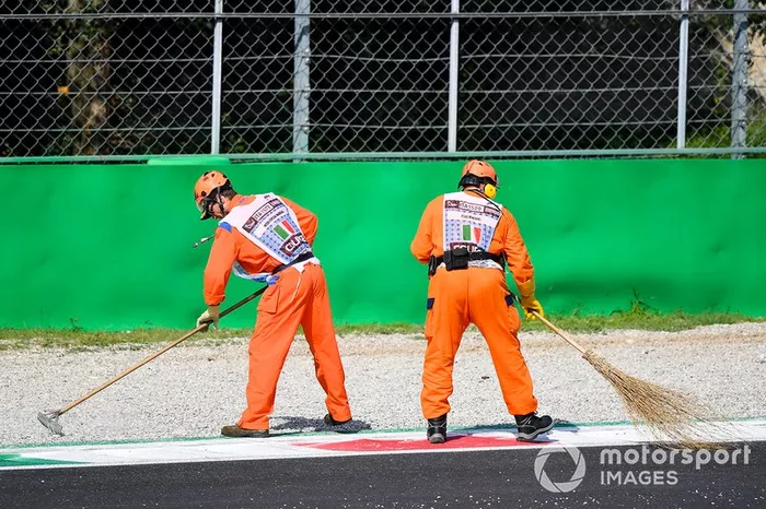 El oficial de pista barre la pista con un cepillo