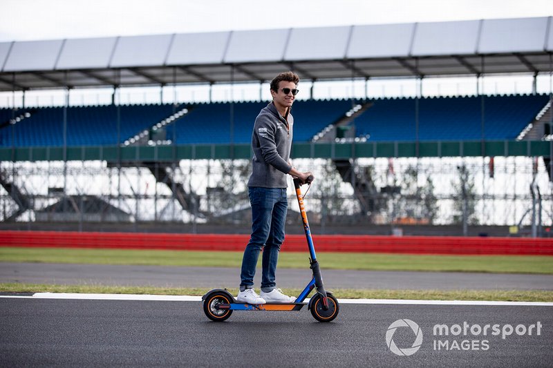 Lando Norris, McLaren walks the track on a scooter