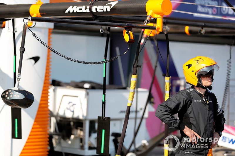 A McLaren pit crew member stands by