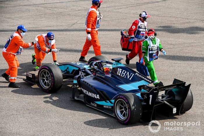 Los oficiales de pista con el monoplaza de Juri Vips, Dams después de hacer un trompo en la salida de la carrera