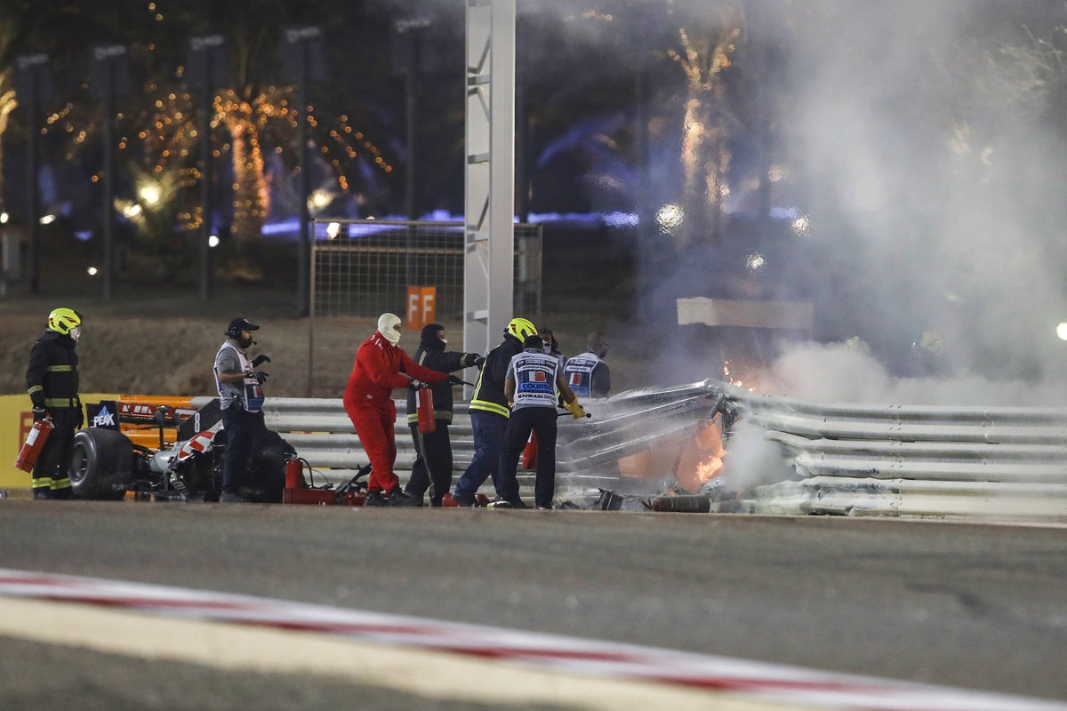 Los oficiales de pista trabajan para apagar el fuego en la escena del accidente