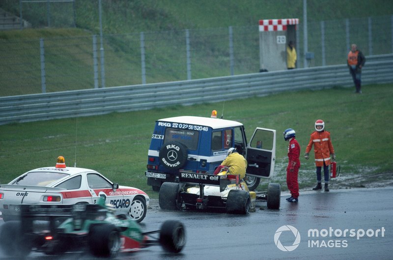 Patrick Tambay beside his damaged Renault RE50 during practice as marshals recover the car and Riccardo Patrese, Alfa Romeo 184T