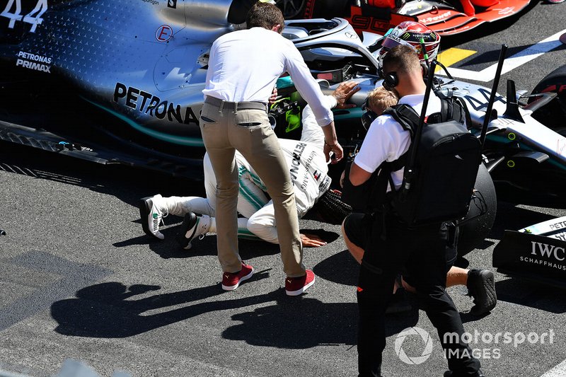 Lewis Hamilton, Mercedes AMG F1, looks under his car as Paul di Resta, Sky Sports F1, interviews him after Qualifying