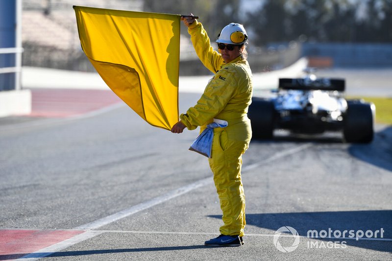 A marshal holds a yellow flag
