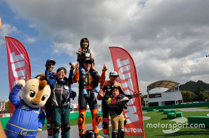 Los Espargaró (Pol y Aleix) celebran junto a Oliveira el podio de la minicarrera