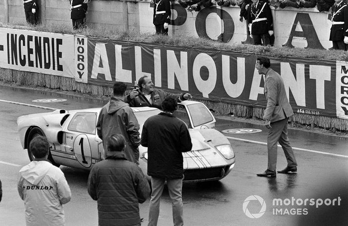 Denis Hulme cabalga en la puerta abierta de su Shelby American Inc, Ford GT-40 Mk II después de la carrera
