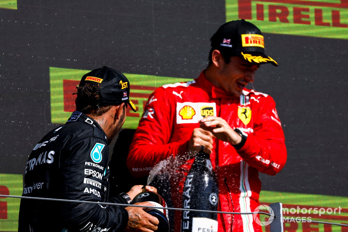 Lewis Hamilton, Mercedes, primo classificato, e Charles Leclerc, Ferrari, secondo classificato, spruzza Champagne sul podio