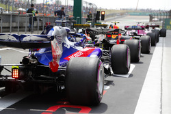 The drivers wait at the pit lane exit to head to the grid