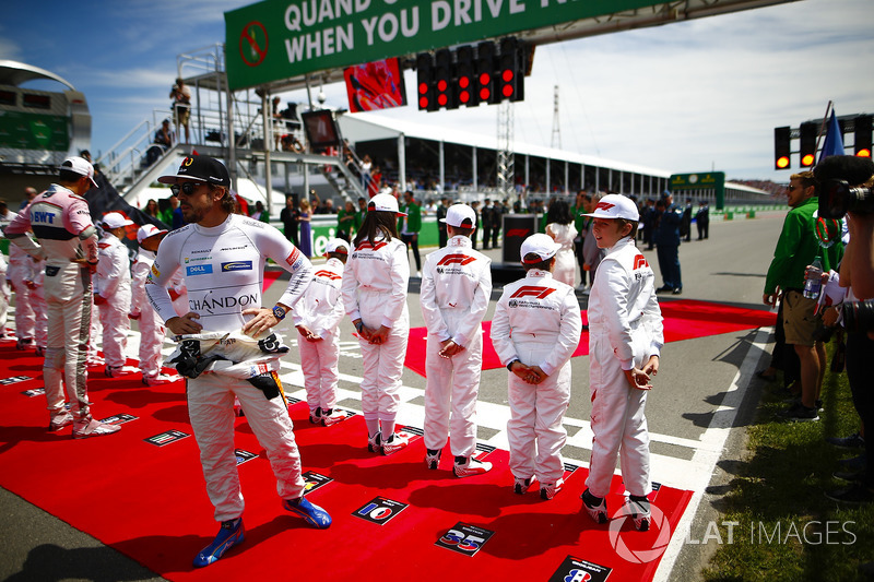 Esteban Ocon, Force India, and Fernando Alonso, McLaren, say hello to the Grid Kid mascots