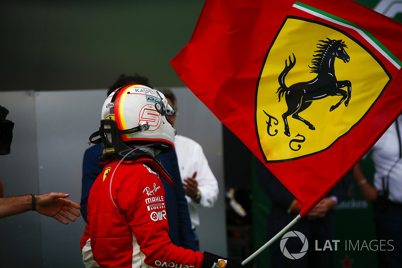 Sebastian Vettel, Ferrari, celebrates victory by waving a Prancing Horse flag