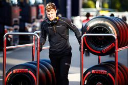 Un mecánico de McLaren rueda un carro de neumáticos Pirelli
