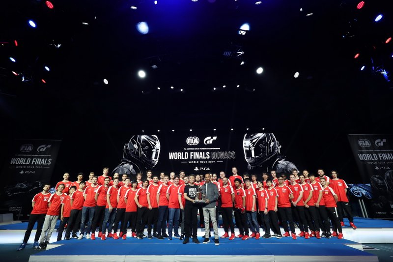 Formula 1 Driver, Lewis Hamilton and producer of Gran Turismo, Kazunori Yamauchi pose for a photo on stage with the competitors