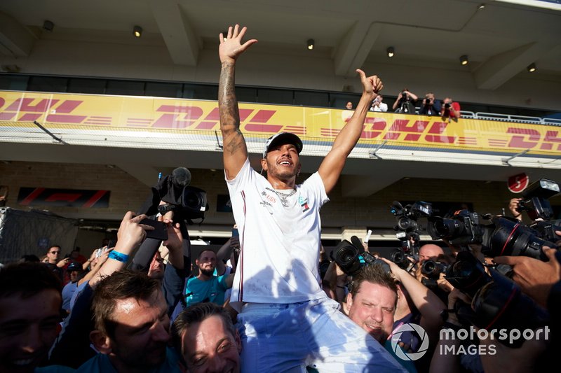 Lewis Hamilton, Mercedes AMG F1, lifts a Union Flag after winning the world championship