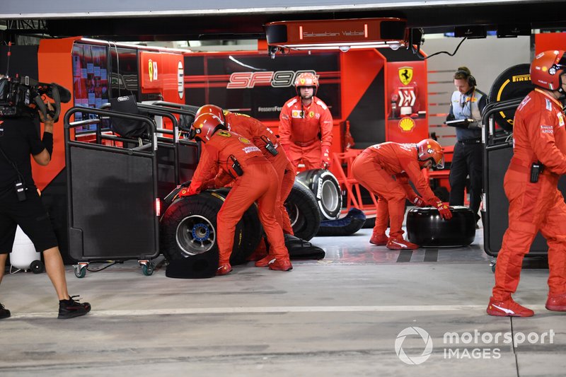 La pit crew Ferrari si prepara per sostituire l'ala anteriore di Sebastian Vettel