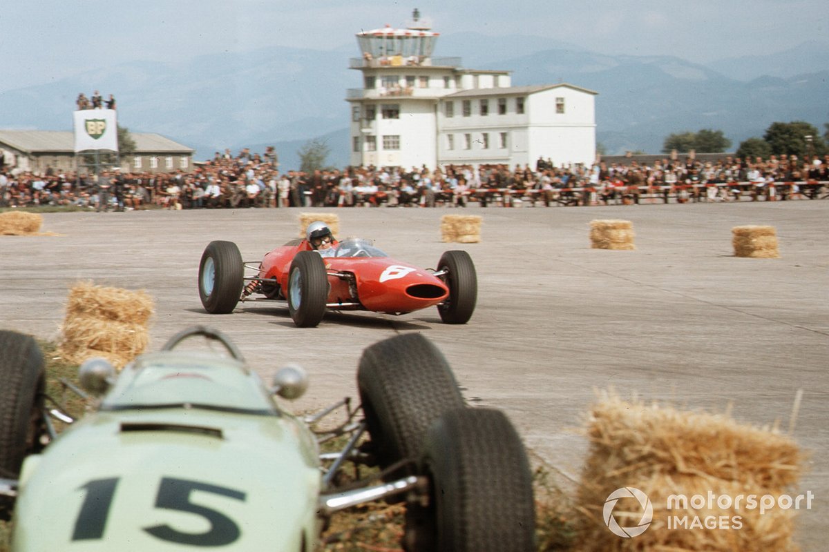 Lorenzo Bandini Ferrari 156 passes the crashed BRP 1-BRM of Trevor Taylor