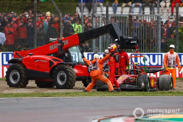 Los oficiales retiran el coche de Carlos Sainz Jr., Ferrari F1-75, de la grava tras su retirada en la primera vuelta