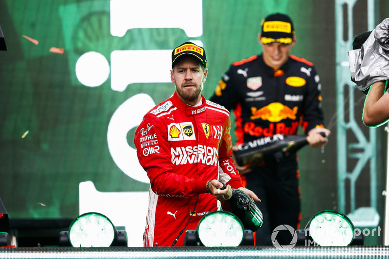 Sebastian Vettel, Ferrari, 2nd position, and Max Verstappen, Red Bull Racing, 1st position, spray Champagne on the podium